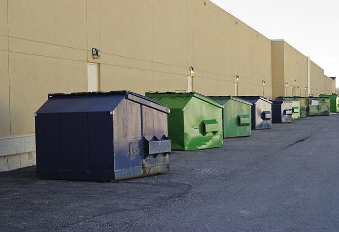 a construction worker disposing of debris into a dumpster in Ashland